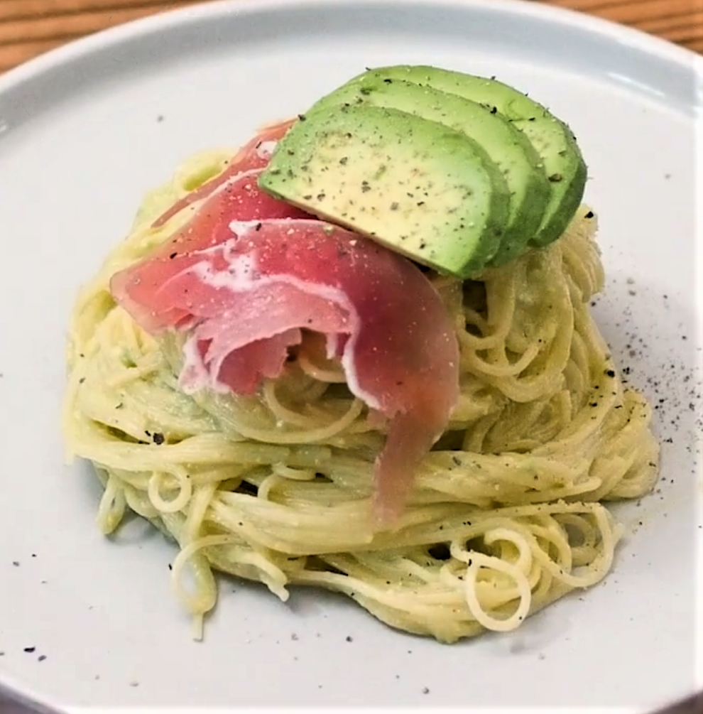 冷製パスタの麺のうえに生ハムとスライスしたアボカドがのっている