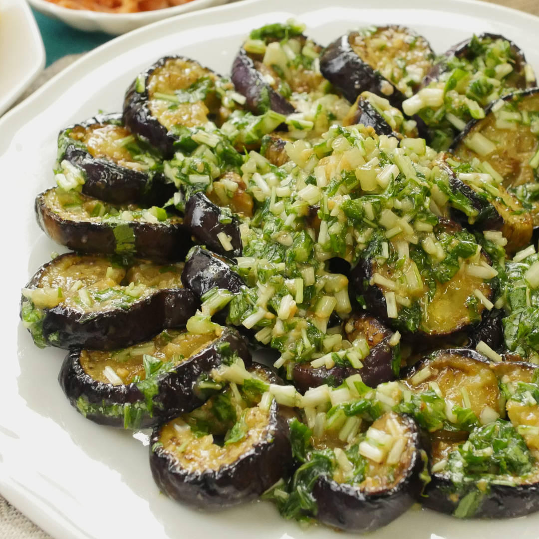 白い皿に盛られた焼きなすと水菜のマリネ