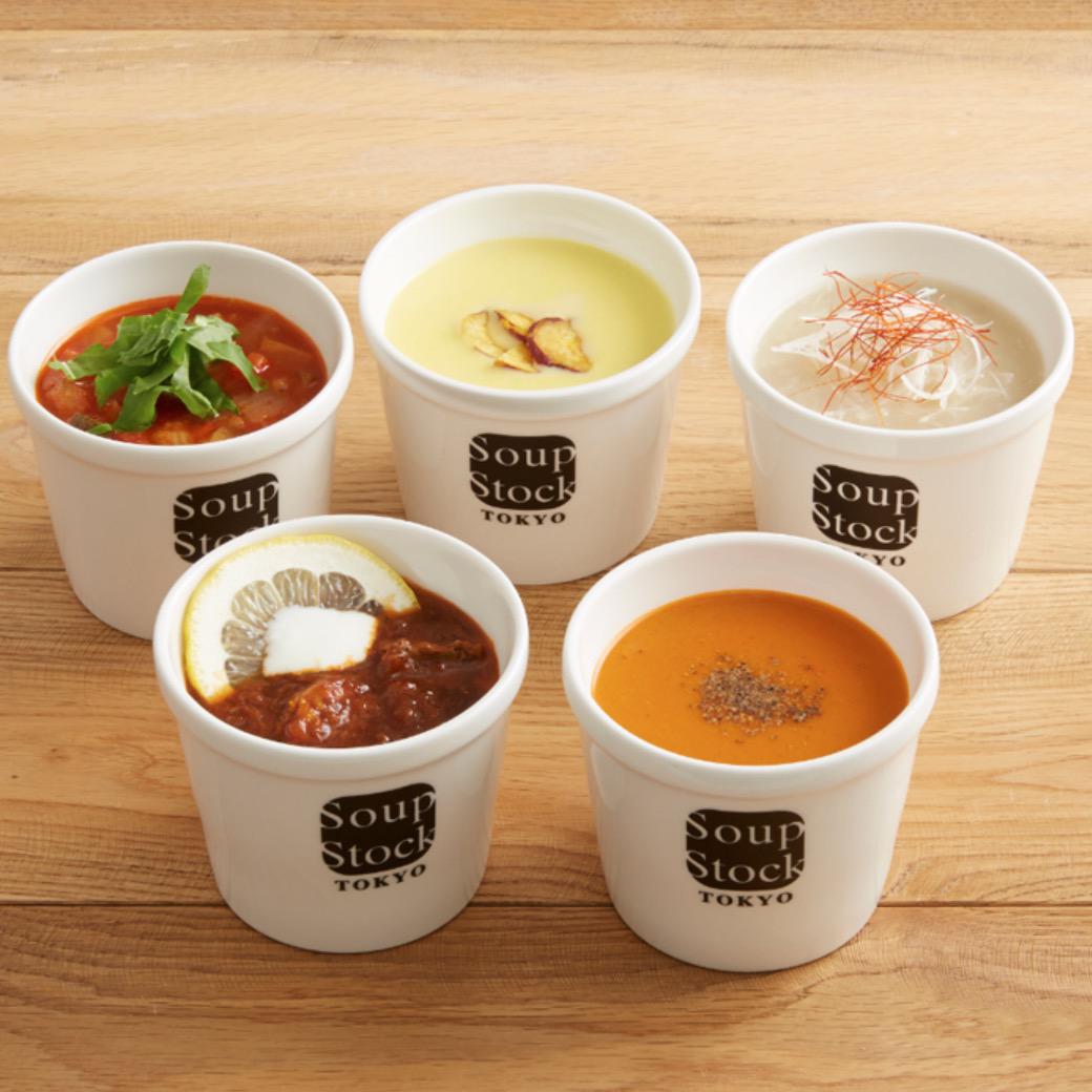 木目調の背景に置かれた白いスープカップに入った5種類のスープ