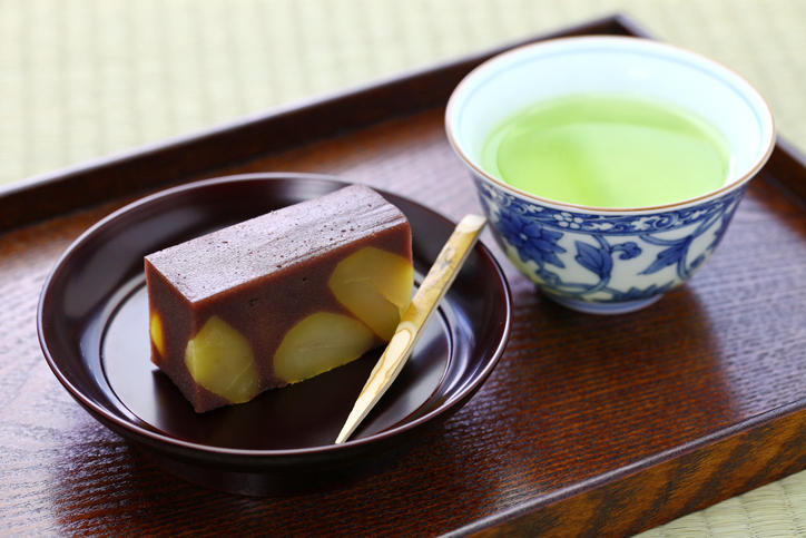 緑茶が入った湯呑みと栗羊羹が置かれている。