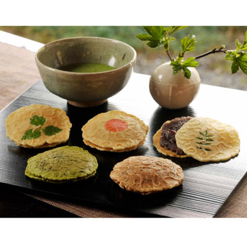 黒いプレートに置かれた煎餅菓子とお抹茶