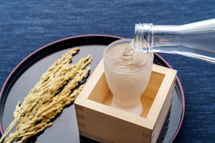 透明のグラスに注がれた日本酒と稲