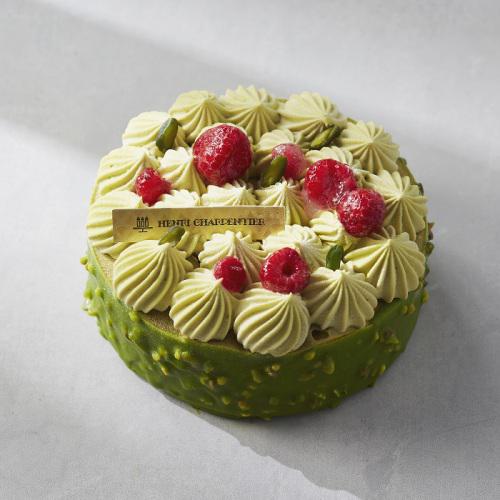 フランボワーズがトッピングされたピスタチオカラーのホールケーキ