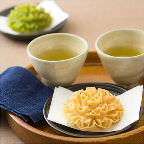 黄色い『塩かりん』と湯呑みに入った緑茶が２つ並べられている