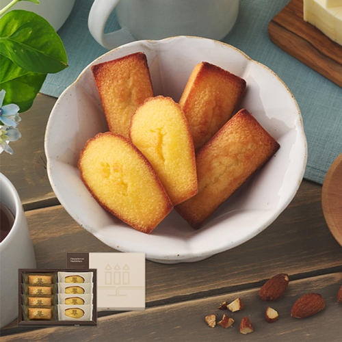 白い菓子鉢に盛られたフィナンシェとマドレーヌ、ブラウンカラーのギフト箱
