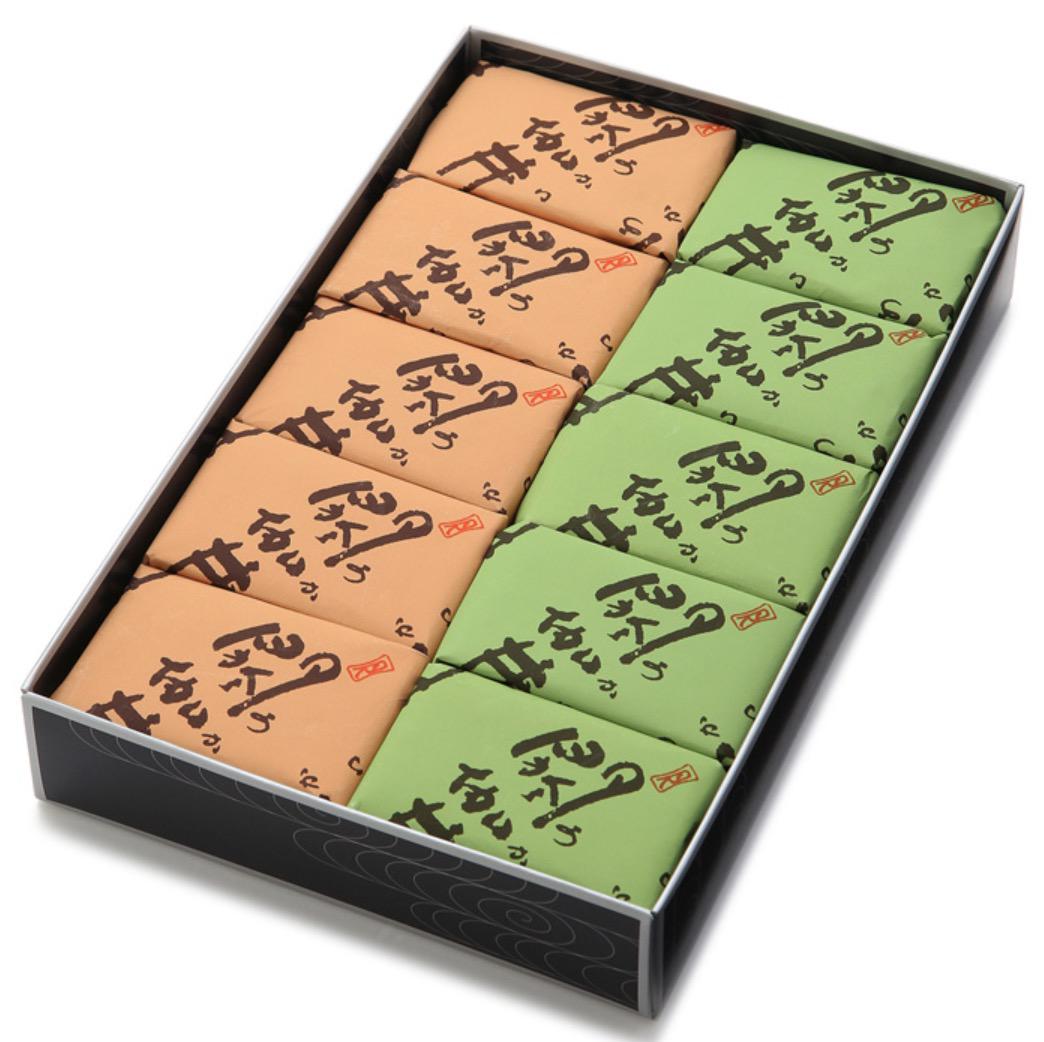 黒い化粧箱に入った緑と淡いオレンジの紙包みに入ったお菓子