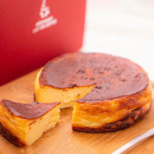 ウッドボードにホールサイズのベイクドチーズケーキがのっている。