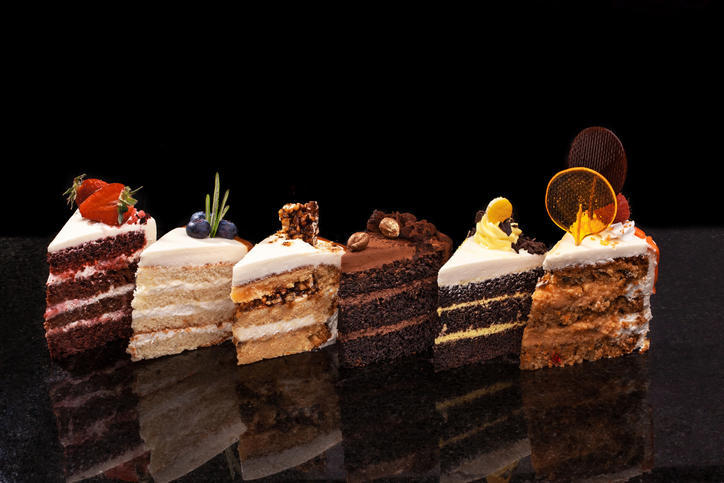 黒い背景に置かれた6つのさまざまなカットケーキ