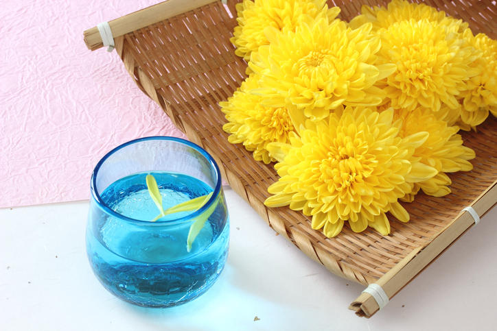ザルに盛られた食用菊と花びらを浮かべた菊酒