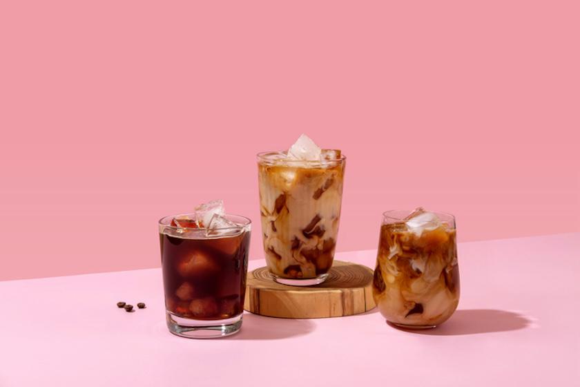 ピンク色を背景に、コーヒーが入ったグラスが3つ並んでいる。