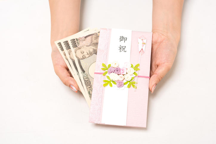 ピンク色のご祝儀袋と3枚の1万円札
