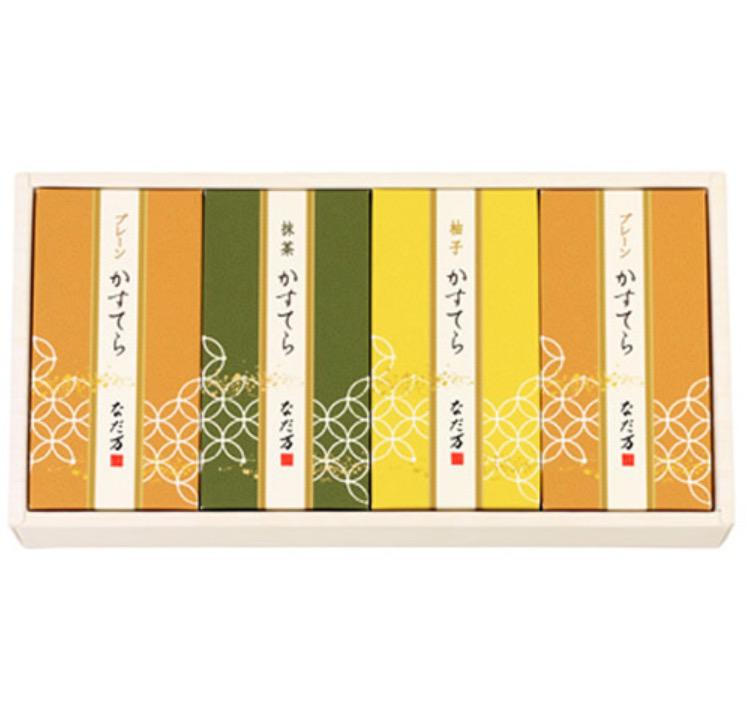 白い化粧箱に入ったオレンジ・緑・黄色のかすてら入りの箱