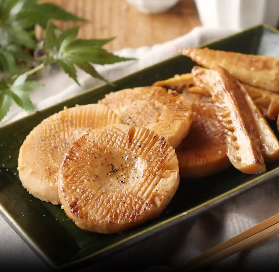 深緑色の和皿に盛られたたけのこのバター醤油ステーキ