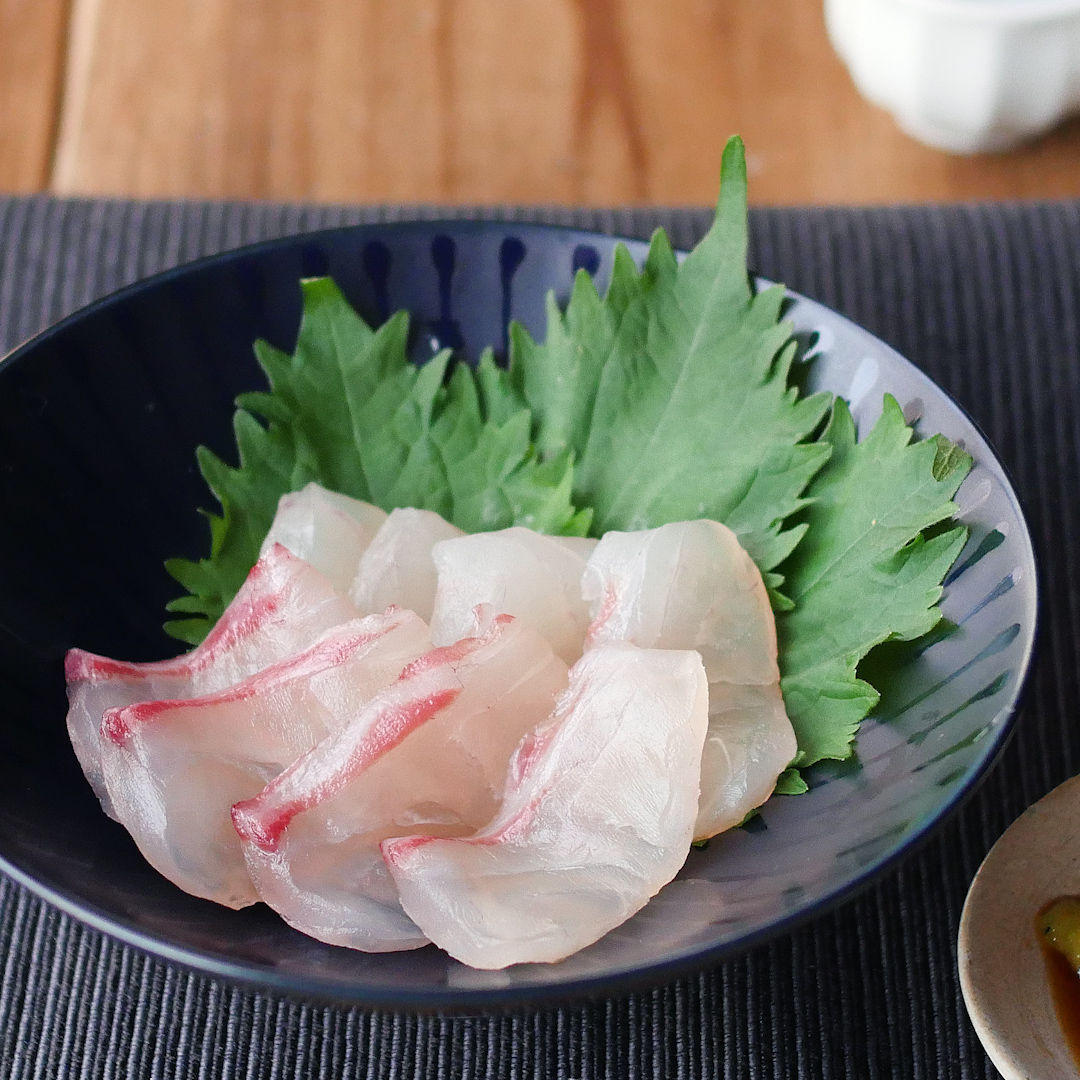 黒い皿に盛られた鯛の昆布締め