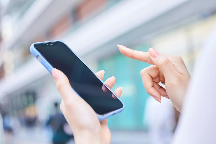 屋外でスマートフォンを使っている手元