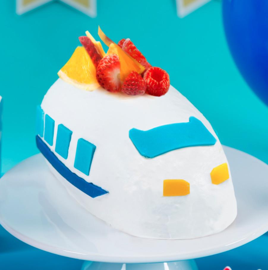 ブルーの背景に置かれた皿の上の電車を模ったケーキ