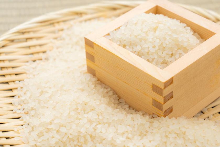 ザルに米がまかれ、その上に米入りの升が置かれている。