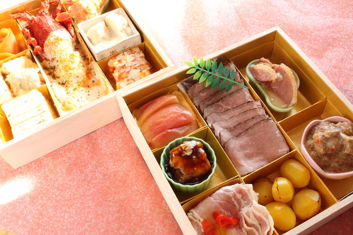 華やかなテーブルに置かれた、お肉料理入りのおせち