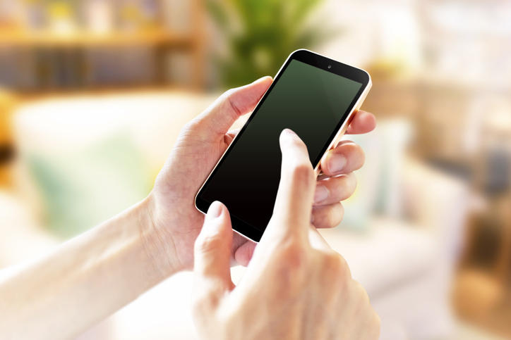 スマホを指でタップする様子