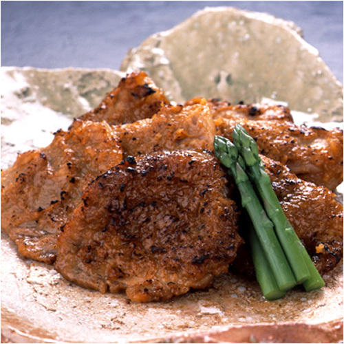 豚肉の味噌漬けを焼いたものとアスパラガスが盛りつけられた皿。
