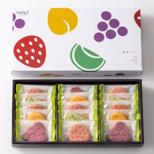 いちごやぶどうの形をした色とりどりの個包装クッキー15枚が、フルーツの絵が描かれた白い紙箱に詰め合わせになっている