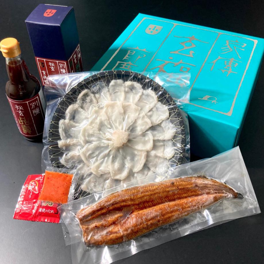 コバルトブルーの化粧箱の前に並んだ真空パックされた鰻の蒲焼きとフグ刺しと瓶入りの調味料