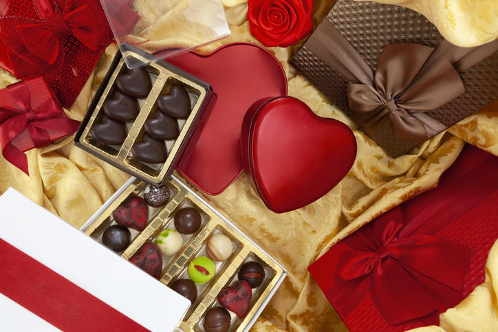 バレンタインチョコとリボンをかけた箱が金色の布の上に置かれている