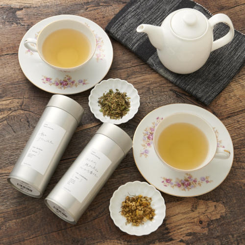 紅茶が入ったティーカップやディーポット、茶葉が盛られた器、パッケージが並んでいる