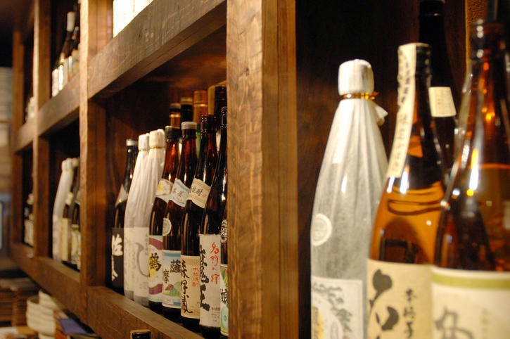 棚にさまざまな日本酒のボトルが並んでいる様子