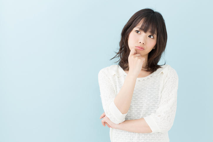 あごに手をあてて考えごとをしている女性