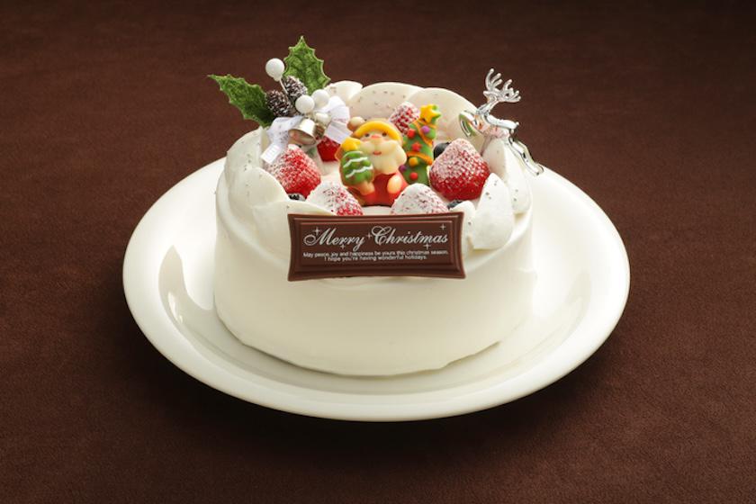 サンタクロースの飾りといちごがのたホールサイズの白いクリスマスケーキ。