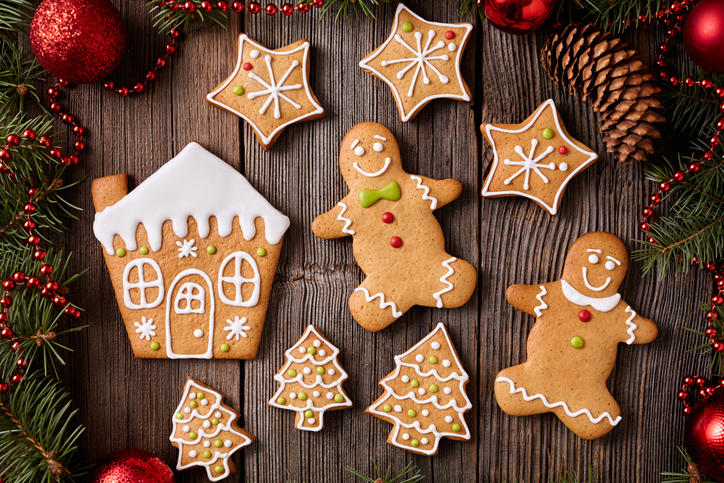 木目調のテーブルにジンジャークッキーが置かれクリスマスの装飾が添えられている。