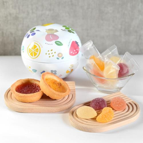 フルーツ柄の丸い缶と皿に盛られたフルーツのタルトとゼリー