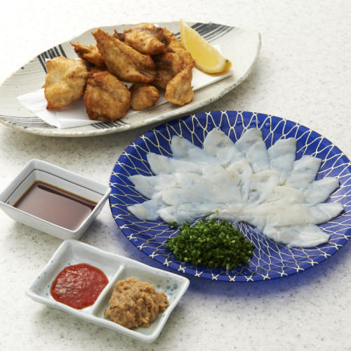 青い皿に盛られたまふぐの刺身と白い皿に盛られたまふぐのから揚げ、薬味皿のふぐ味噌