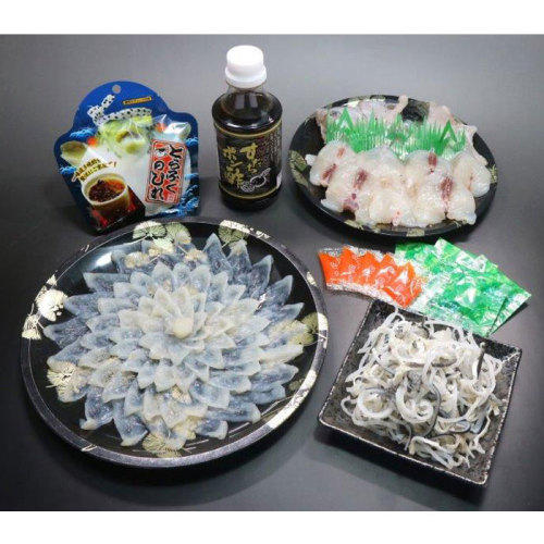 黒い皿に盛り付けられたてっさ・皮刺し・鍋用切身アラ、袋や瓶に入った干しヒレ・ぽん酢・薬味