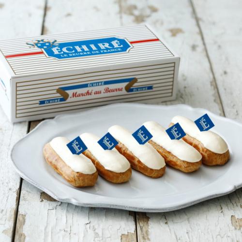 シュー生地にバタークリームがかかったお菓子が白い皿に盛られており、その横には化粧箱が置かれている