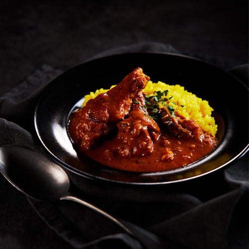 黒い器に盛られた骨付きタンドリーチキンカレー