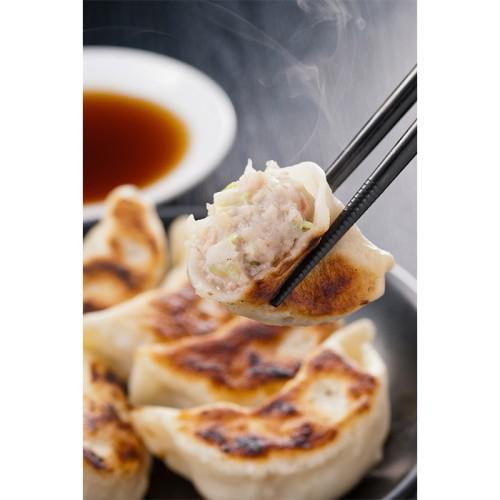 焼き餃子を箸でつまんでいる