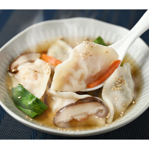 器に盛られた水餃子をスプーンですくっている