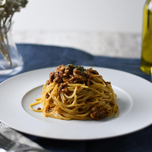 皿のうえに牛肉がたっぷりのったパスタが盛り付けられている