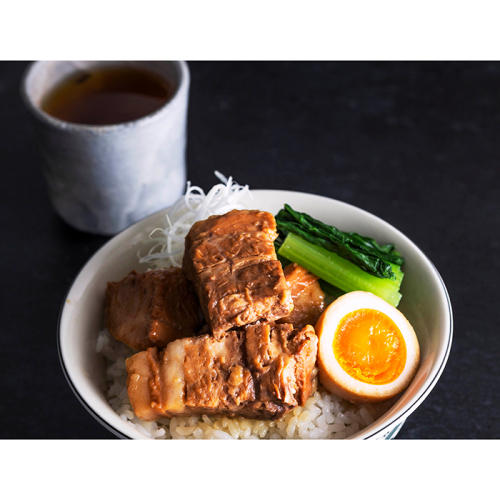 どんぶりにはいったご飯に盛られた豚の角煮、煮卵、青菜