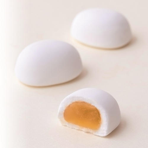 白くて丸い和菓子2個と、半分にカットされて中の黄身餡が見えた白い和菓子が置かれている
