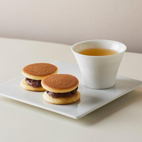 白い皿の上に、ミニサイズのどら焼き2個と、お茶が入った湯呑みが置かれている