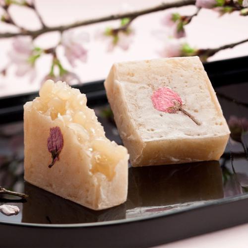 桜の花の塩漬けが飾られたきんつばが、黒い皿の上に置かれている