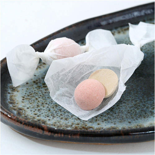ダークな色合いの和皿に盛られた紅白一対の干菓子