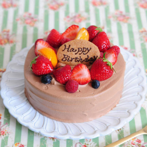 いちごやブルーベリーなどでデコレーションされたホールのチョコレートケーキ