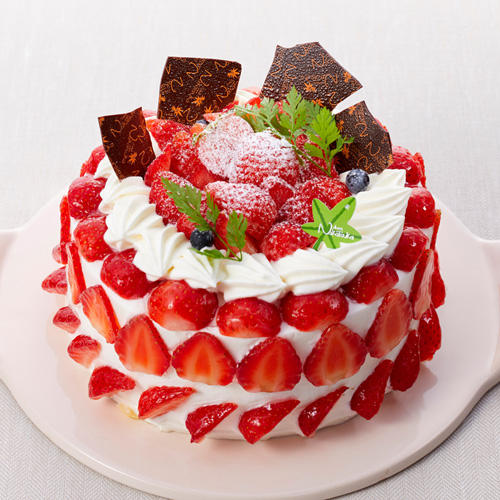 生クリームをぬったホールケーキがたっぷりのイチゴでデコレーションされている