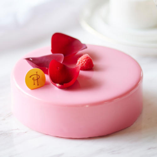 バラの花びらがのった、ピンクのグラサージュケーキ