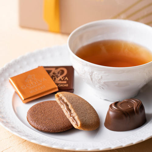 紅茶と白い皿にのったゴディバの「チョコレート&クッキー アソートメント チョコレート13粒入/クッキー8枚入」