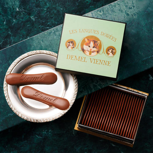 グリーンの箱とシルバーの皿にのったデメルの「ソリッドチョコ猫ラベル ミルク」